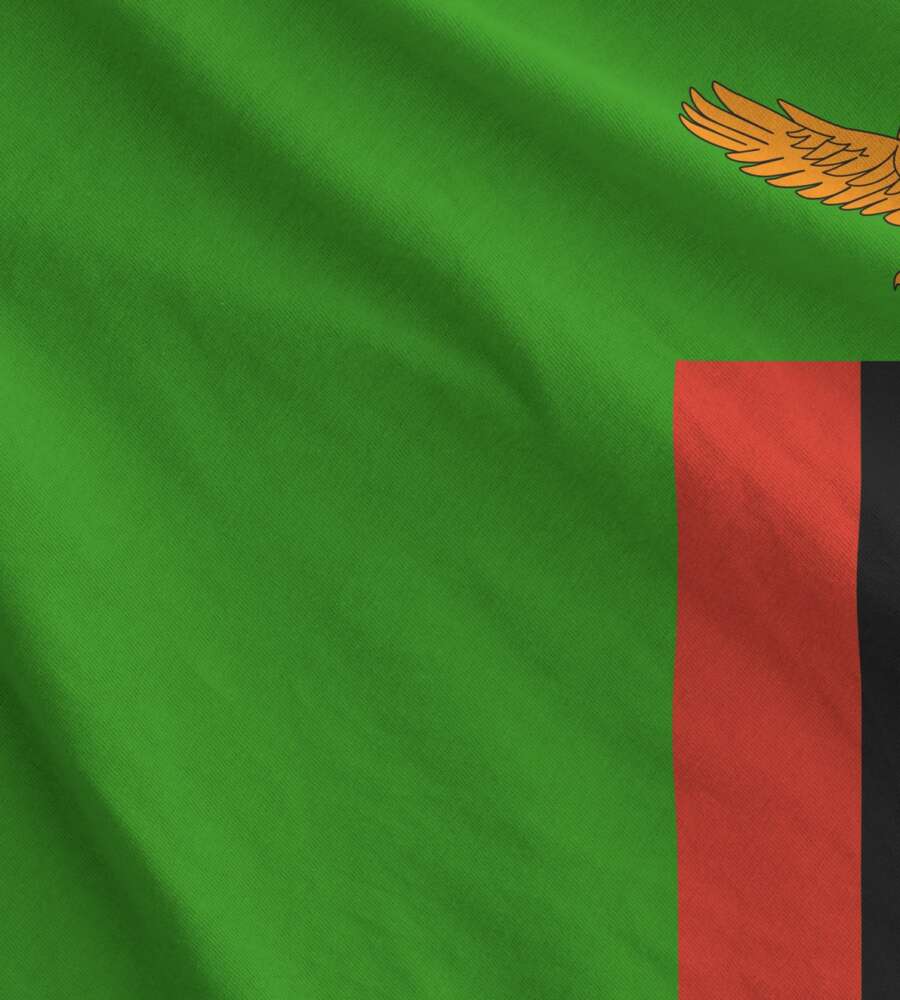 Zambia flag depicted on folded wavy fabric of old cloth